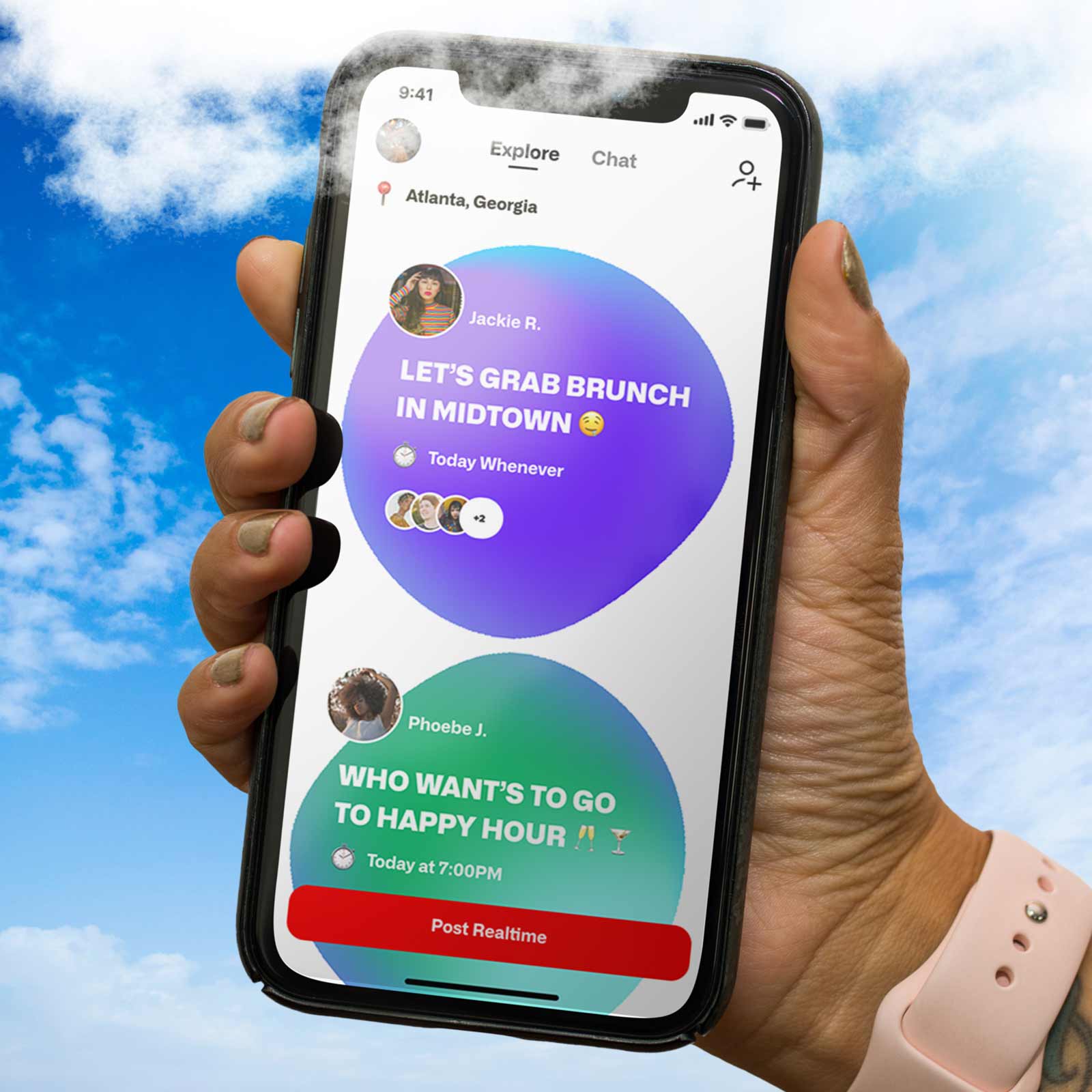 A hand holding a phone with the homepage of the RealTime app.